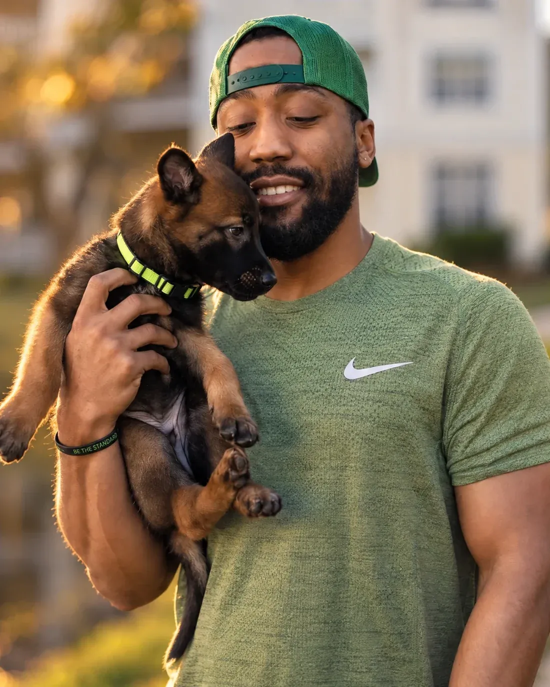 Cam Boyd holding Draco, his first Belgian Malinois, as a puppy