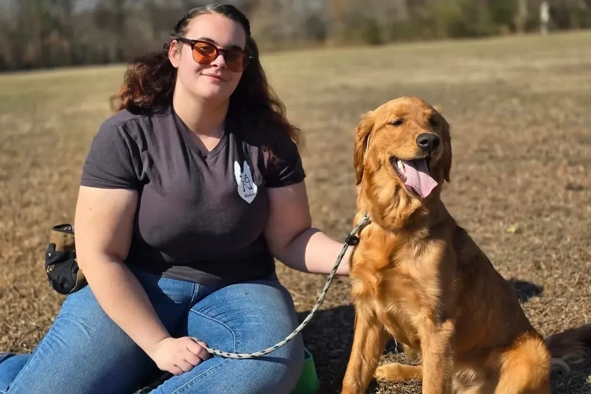 K9aholics trainer sitting with a golden retriever
